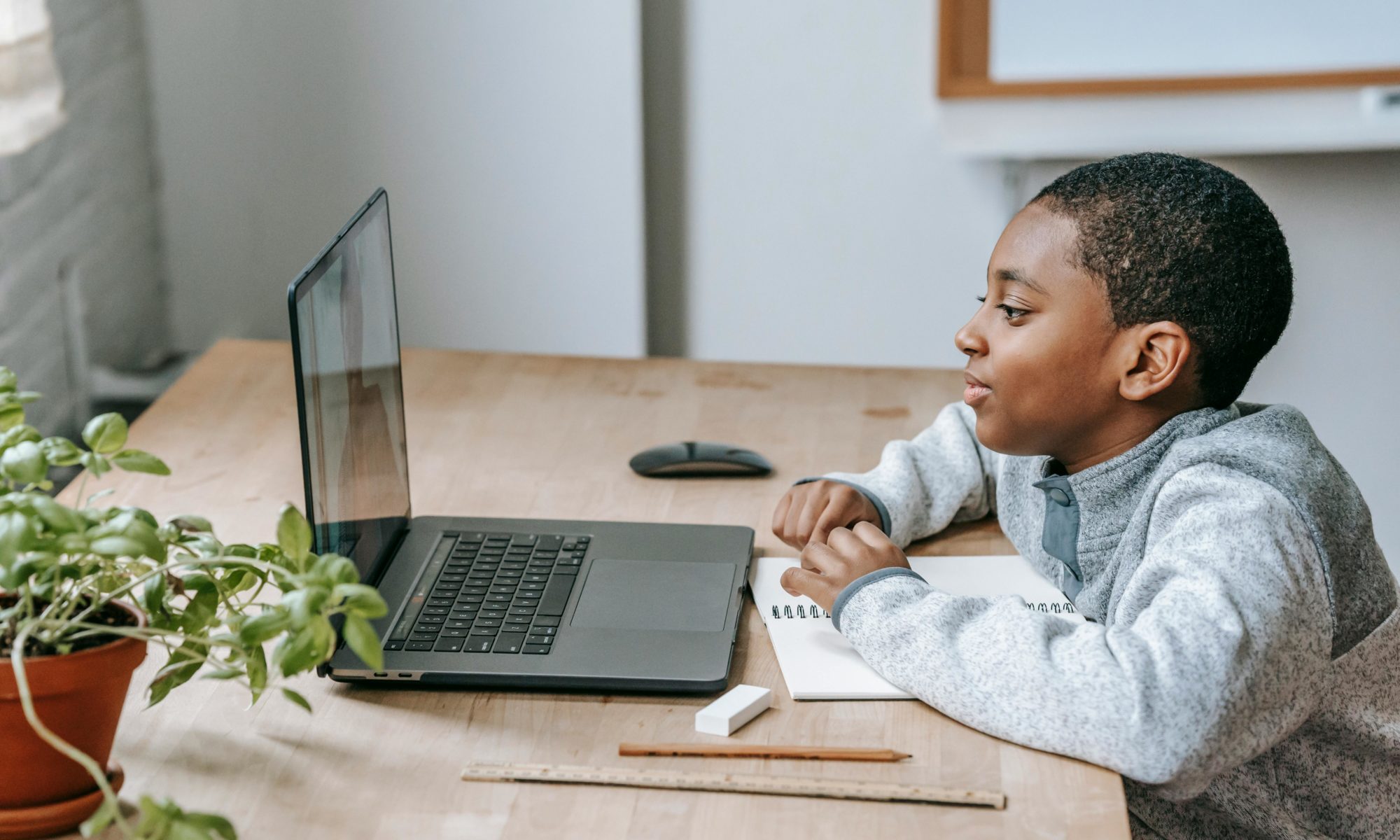 Un parent et son enfant collaborent sur un projet scolaire à la maison, illustrant l'implication parentale dans l'éducation malgré un planning de garde 70/30.